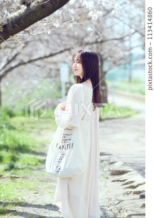 一個女人沿著櫻花樹河床散步 一個女人沿著櫻花樹河床散步 113414860