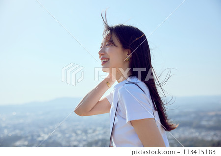 Woman on top of a hill gazing into the distance Woman on top of a hill gazing into the distance 113415183