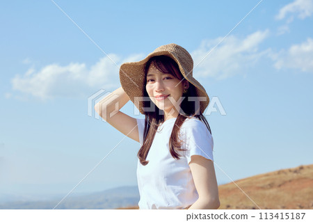 Woman on top of a hill gazing into the distance 113415187