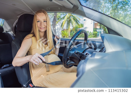Pregnant woman driving with safety belt on in the car. Confident and capable, a pregnant woman takes the wheel, driving with care and determination as she navigates the journey of motherhood Pregnant woman driving with safety belt on in the car. Confident and capable, a pregnant woman takes the wheel, driving with care and determination as she navigates the journey of motherhood 113415302