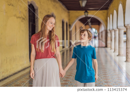 Mother and son tourists explore the vibrant streets of Valladolid, Mexico, immersing herself in the rich culture and colorful architecture of this charming colonial town Mother and son tourists explore the vibrant streets of Valladolid, Mexico, immersing herself in the rich culture and colorful architecture of this charming colonial town 113415374