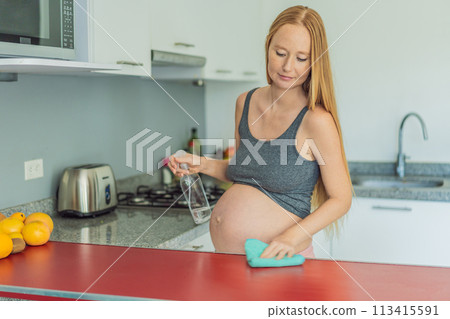 Efficient and dedicated, a pregnant woman tackles kitchen chores, ensuring a clean and organized space, exemplifying resilience and care during her pregnancy 113415591