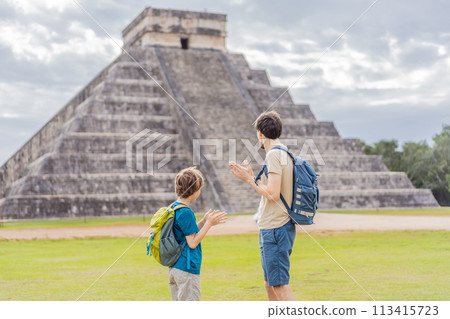Father and son tourists observing the old pyramid and temple of the castle of the Mayan architecture known as Chichen Itza these are the ruins of this ancient pre-columbian civilization and part of Father and son tourists observing the old pyramid and temple of the castle of the Mayan architecture known as Chichen Itza these are the ruins of this ancient pre-columbian civilization and part of 113415723