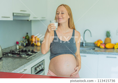 Weighing the pros and cons of milk during pregnancy, a thoughtful pregnant woman stands in the kitchen with a glass, contemplating the decision to include or avoid milk for her and her baby's well Weighing the pros and cons of milk during pregnancy, a thoughtful pregnant woman stands in the kitchen with a glass, contemplating the decision to include or avoid milk for her and her baby's well 113415736