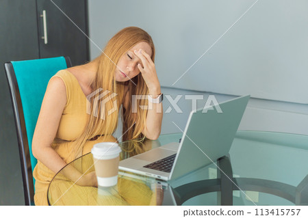 Tired pregnant woman at work drinks coffee caution advised due to potential harm of caffeine during pregnancy 113415757