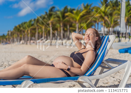 Basking in seaside tranquility, a pregnant woman lounges on a sun lounger, embracing the soothing ambiance of the beach for a moment of serene relaxation Basking in seaside tranquility, a pregnant woman lounges on a sun lounger, embracing the soothing ambiance of the beach for a moment of serene relaxation 113415771
