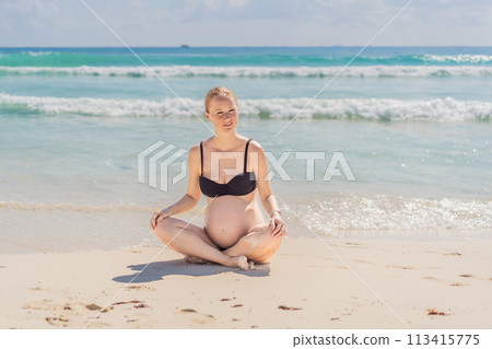 Harmonizing mind and body, a pregnant woman gracefully practices yoga on the beach, embracing the serenity of the seaside for a tranquil and mindful pregnancy experience 113415775