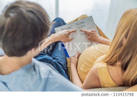 Expectant couple joyfully selects a name for their unborn daughter, savoring the special moment of choosing a meaningful identity for their growing family 113415798