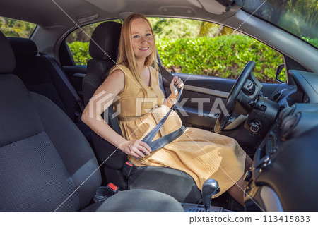 Pregnant woman driving with safety belt on in the car. Confident and capable, a pregnant woman takes the wheel, driving with care and determination as she navigates the journey of motherhood 113415833