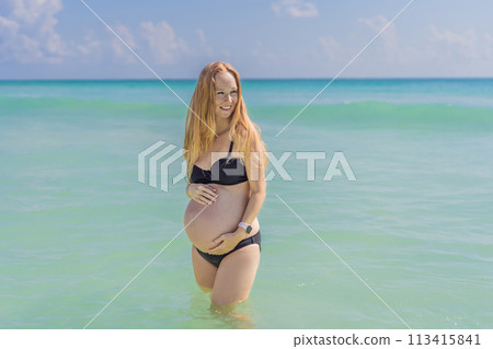 In the idyllic embrace of the Caribbean Sea, a pregnant woman finds bliss, savoring the warmth and serenity of the tropical waters during her pregnancy 113415841