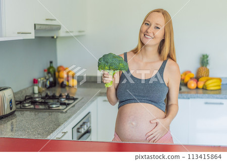 Embracing a nutrient-rich choice, a pregnant woman eagerly prepares to enjoy a wholesome serving of broccoli, prioritizing healthy and nourishing options during her pregnancy 113415864