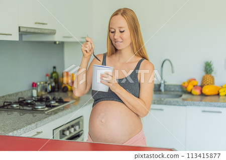 Happy pregnant young woman eating ice cream Happy pregnant young woman eating ice cream 113415877