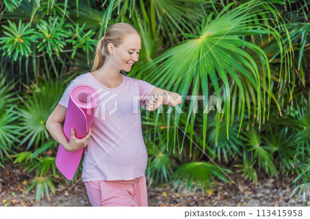 Energetic pregnant woman takes her workout outdoors, using an exercise mat for a refreshing and health-conscious outdoor exercise session 113415958