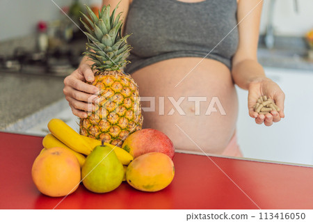 Balancing choices for optimal nutrition, a pregnant woman decides between the wholesome goodness of fresh fruits and the convenience of vitamin tablets, ensuring a well-rounded approach to her 113416050