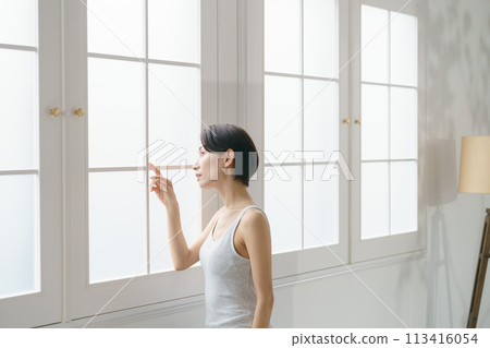一名30多歲的女性好奇地看著窗外 113416054