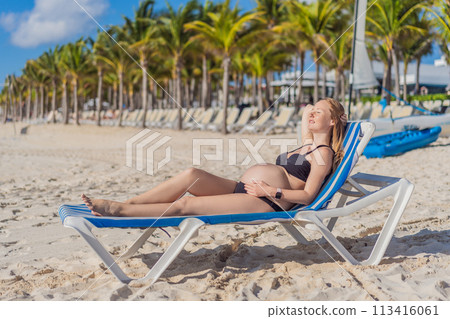 Basking in seaside tranquility, a pregnant woman lounges on a sun lounger, embracing the soothing ambiance of the beach for a moment of serene relaxation Basking in seaside tranquility, a pregnant woman lounges on a sun lounger, embracing the soothing ambiance of the beach for a moment of serene relaxation 113416061