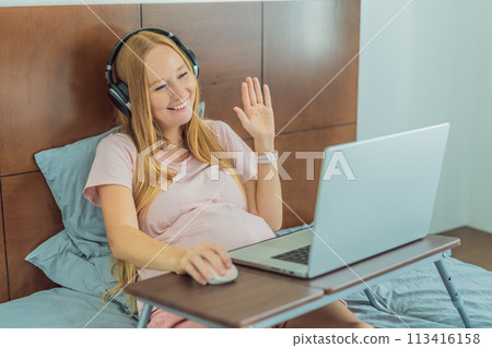 Pregnant woman working on laptop. Expectant woman efficiently works from home during pregnancy, blending professional commitment with maternal duties 113416158