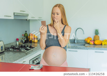 Contemplating the sweet dilemma, a pregnant woman ponders the decision to indulge in chocolate during pregnancy, weighing the delightful treat's potential impact on her maternal journey Contemplating the sweet dilemma, a pregnant woman ponders the decision to indulge in chocolate during pregnancy, weighing the delightful treat's potential impact on her maternal journey 113416258
