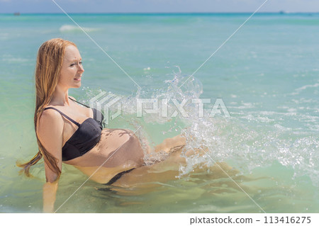 In the idyllic embrace of the Caribbean Sea, a pregnant woman finds bliss, savoring the warmth and serenity of the tropical waters during her pregnancy 113416275