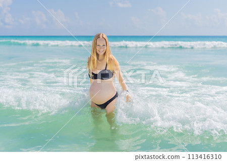 In the idyllic embrace of the Caribbean Sea, a pregnant woman finds bliss, savoring the warmth and serenity of the tropical waters during her pregnancy 113416310