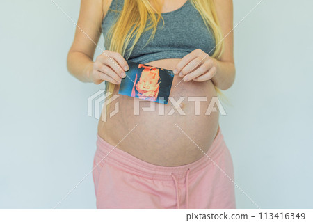 Joyful pregnant woman shares the exciting news, proudly displaying her positive pregnancy test and a heartwarming ultrasound photo Joyful pregnant woman shares the exciting news, proudly displaying her positive pregnancy test and a heartwarming ultrasound photo 113416349