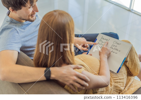 Expectant couple joyfully selects a name for their unborn son, savoring the special moment of choosing a meaningful identity for their growing family 113416396