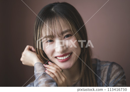 A woman in her twenties smiling at the camera 113416730