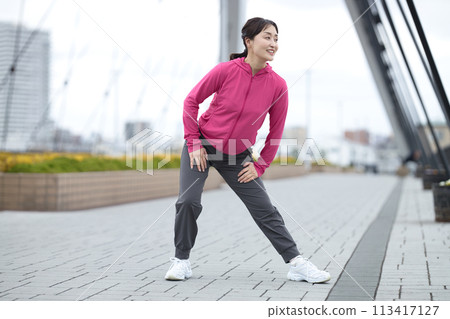穿著運動服伸展身體的中年婦女 穿著運動服伸展身體的中年婦女 113417127