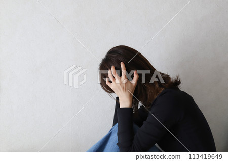 A depressed woman holding her head 113419649