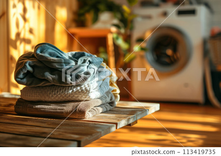 Washed clothes on board against background with washing machine in home laundry Washed clothes on board against background with washing machine in home laundry 113419735