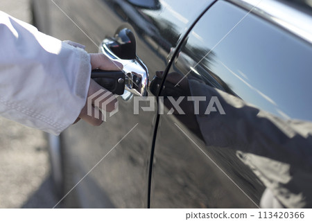 Hand holding car keys at door Hand holding car keys at door 113420366