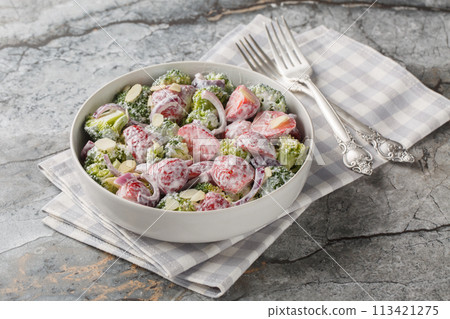Broccoli salad with fresh strawberries, red onion, almonds and Greek yogurt close-up in a plate. Horizontal 113421275