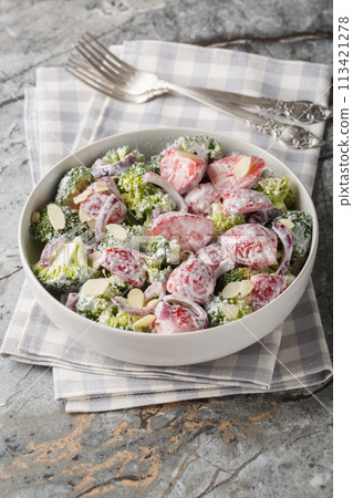 Salad of broccoli, strawberries, red onion and almonds dressed with yogurt close-up in a plate. Vertical Salad of broccoli, strawberries, red onion and almonds dressed with yogurt close-up in a plate. Vertical 113421278