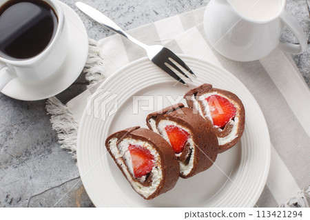 Chocolate cake roll with fresh strawberries and cream cheese closeup on. Horizontal top view Chocolate cake roll with fresh strawberries and cream cheese closeup on. Horizontal top view 113421294