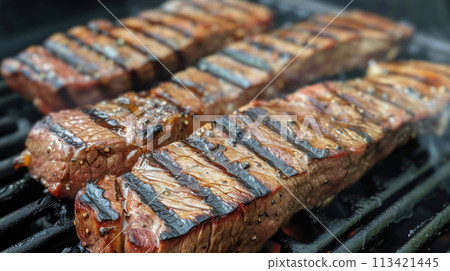 Pieces of beef steak are cooked on the grill 113421445