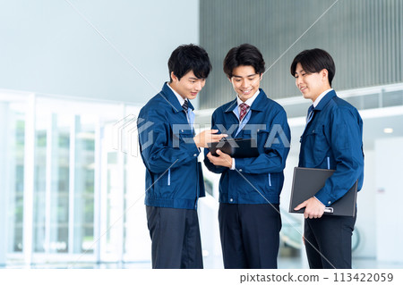 Young male engineers in work clothes having a meeting 113422059