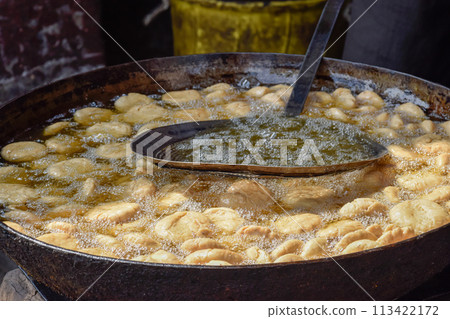 Traditional Namkeen Indian snacks and Samosas frying on street food and markets Traditional Namkeen Indian snacks and Samosas frying on street food and markets 113422172