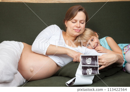 Expectant Mother and Daughter Looking at Ultrasound Expectant Mother and Daughter Looking at Ultrasound 113422564