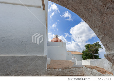 Old stone arch framing the terracotta dome of Puig de Missa church in Ibiza 113422875