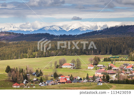 Spring landscape with village under snowy mountains. Spring landscape with village under snowy mountains. 113423059