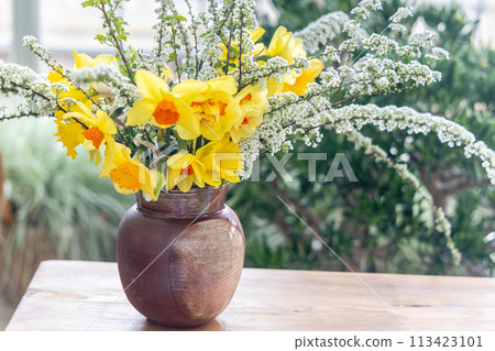 Still life with daffodil flowers in vase on table. 113423101
