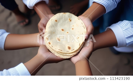 Top view of the hands of different children are separated and holding a stack of flatbread 113423190