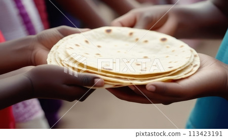 Close up of hands of children are separated and holding a stack of flatbread-pete Close up of hands of children are separated and holding a stack of flatbread-pete 113423191