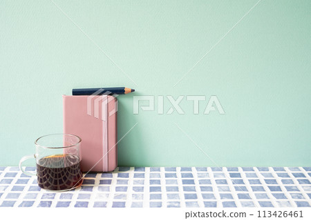 Diary notebook, pencil, coffee on blue tile desk. mint wall background. workspace 113426461