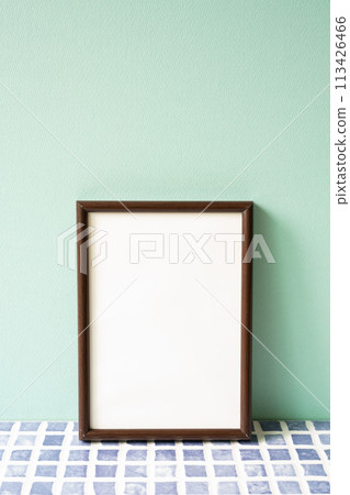 Wooden picture frame on blue tile shelf. mint wall background. copy space Wooden picture frame on blue tile shelf. mint wall background. copy space 113426466