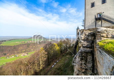 A view of the historic Konigstein Fortress in Saxony, with visitors on the ramparts and the Elbe River in the background. Garmany 113426667