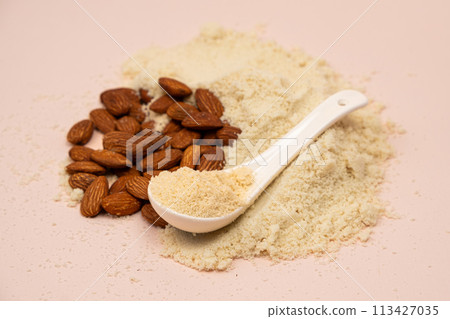 Almond flour and almonds on a beige background Almond flour and almonds on a beige background 113427035