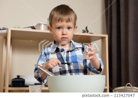 Cute toddler making dough. Toddlers in the kitchen. 113427047