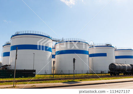 Row many large industrial fuel storage white tanks clear blue sky background on sunny day. Oil storage refinery depot liquid facilities. Energy hazmat railroad transportation storage and distribution Row many large industrial fuel storage white tanks clear blue sky background on sunny day. Oil storage refinery depot liquid facilities. Energy hazmat railroad transportation storage and distribution 113427137