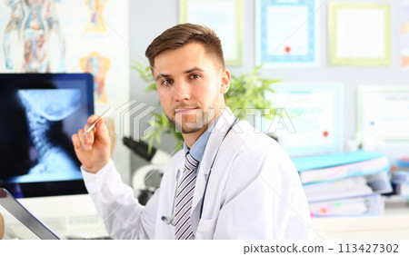 Doctor examines x-ray of cervical spine closeup Doctor examines x-ray of cervical spine closeup 113427302